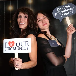 Guests holding community signs at a nonprofit gala photo booth