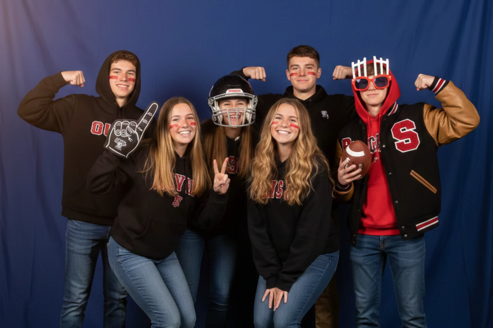 Students in letter jackets flexing at the booth