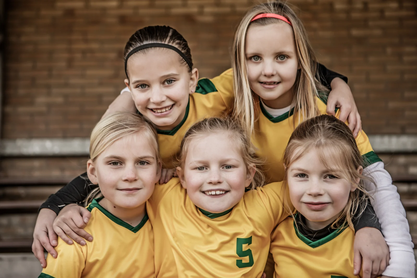Young soccer players piled together for a team photo